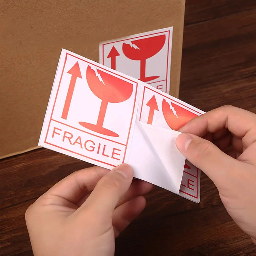 fragile warning labels being applied to box