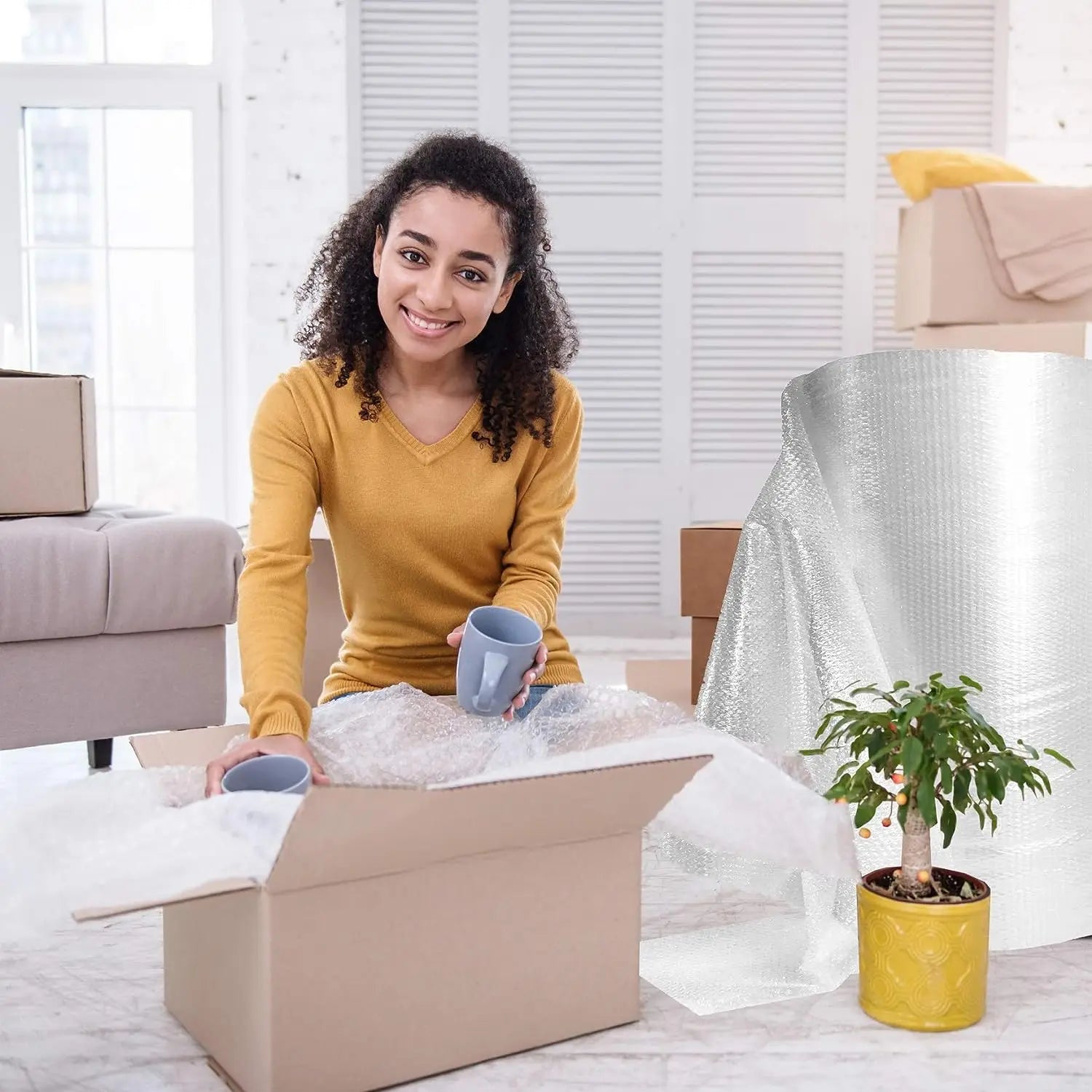 woman putting cups in a box with bubble wrap